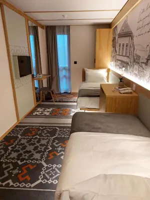 a hotel room with two beds and a tv at Lipa Hotel in Travnik