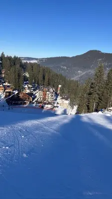 a snow covered field with a town in the background at Apartman Royal Vlašić in Vlasic