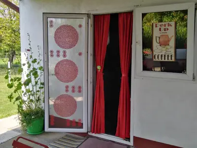 a door of a house with a red curtain at Blossom Cottage - ''Green Tourism'' in Laktaši