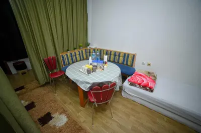 a room with a table and chairs and a bed at Prenoćište KRAJINA in Velika Kladuša