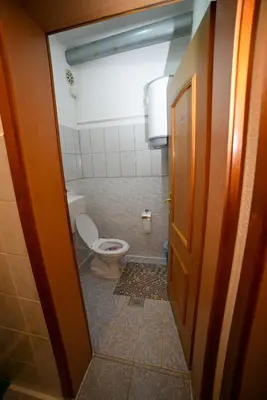 a small bathroom with a toilet and a door at Prenoćište KRAJINA in Velika Kladuša