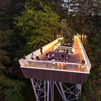 a group of people on a walkway in a forest at Riverside Panorama Apartment 1 near City Center Brko 1 in Banja Luka