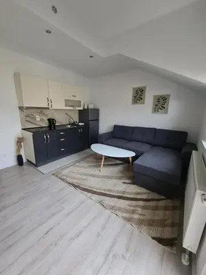 a living room with a blue couch and a table at Čičak in Livno
