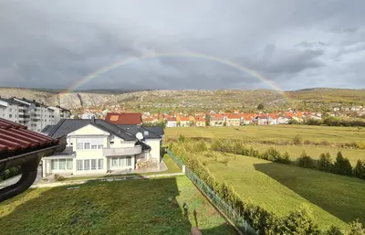 a rainbow in the sky over a house with a yard at Čičak in Livno