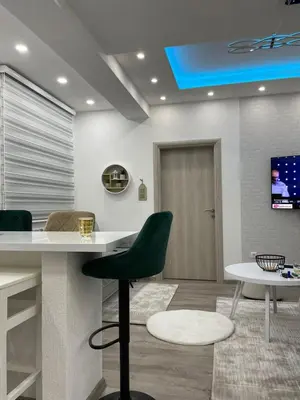 a kitchen with a white counter and a green chair at Apartmani Porodica Karalić Vlašić in Vlasic