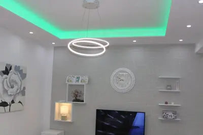 a green light hanging from a ceiling with a clock at Apartmani Porodica Karalić Vlašić in Vlasic