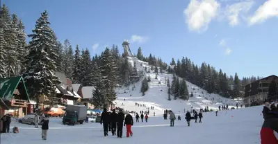 a group of people walking in the snow on a ski slope at Apartmani Porodica Karalić Vlašić in Vlasic