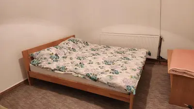 a bed with a floral comforter on it at Winter apartman Vlasic in Šišava