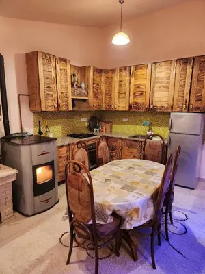 a kitchen with a table and a stove and a refrigerator at Winter apartman Vlasic in Šišava