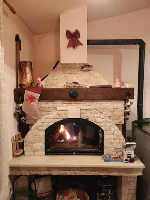 a stone fireplace in a living room with a fire place at Winter apartman Vlasic in Šišava