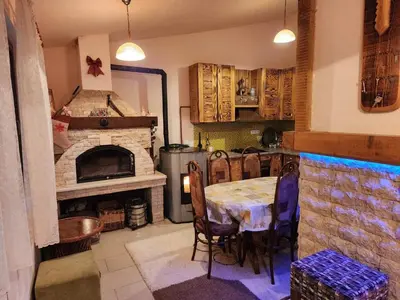 a kitchen with a table and a brick fireplace at Winter apartman Vlasic in Šišava