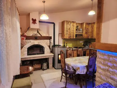 a kitchen with a table and a stone fireplace at Winter apartman Vlasic in Šišava