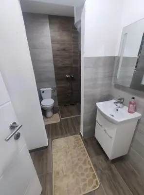 a bathroom with a white sink and a toilet at NEER in Živinice