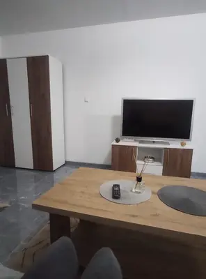 a living room with a table and a television at NEER in Živinice