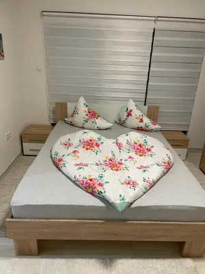 a bed with a heart shaped blanket on it at Apartman Ćuprija in Cazin