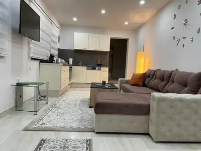 a living room with a couch and a kitchen at Apartman Ćuprija in Cazin