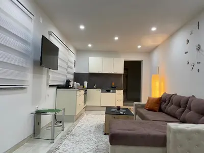 a living room with a couch and a kitchen at Apartman Ćuprija in Cazin