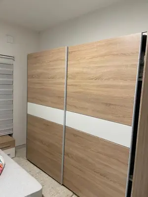 a closet with wooden doors in a bedroom at Apartman Ćuprija in Cazin