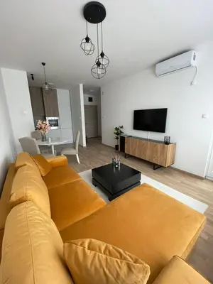 a living room with a yellow couch and a flat screen tv at Apartment City Park in Banja Luka