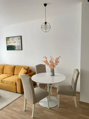 a living room with a table and chairs and a couch at Apartment City Park in Banja Luka