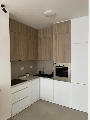 a kitchen with white cabinets and stainless steel appliances at Apartment City Park in Banja Luka