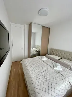 a bedroom with two beds and a mirror at Apartment City Park in Banja Luka