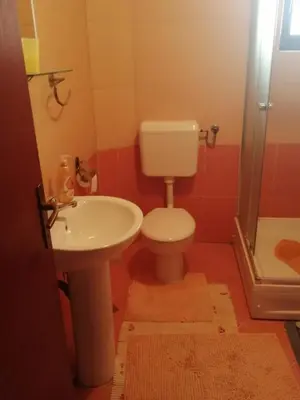 a bathroom with a toilet and a sink at Apartman Vuvuzela in Kupres