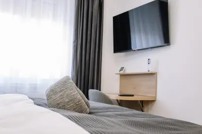 a bedroom with a bed and a television on the wall at Apartments Hana City Center in Livno