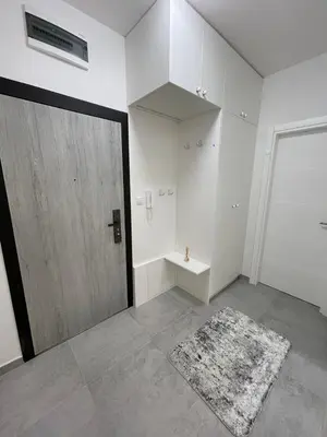 a room with a door and a rug and a mirror at Apartman Blok 51 in Banja Luka