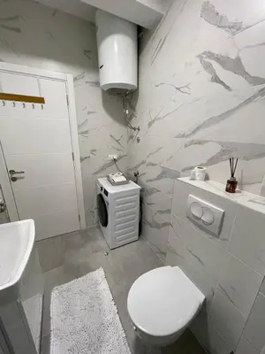 a white bathroom with a toilet and a sink at Apartman Blok 51 in Banja Luka