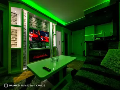 a green room with a table and a tv at Apartmani AMONA STAN NA DAN in Doboj