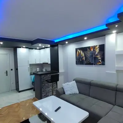 a living room with a couch and a kitchen at Apartmani AMONA STAN NA DAN in Doboj