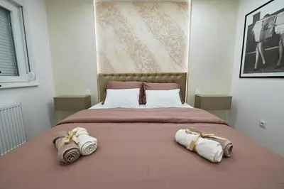 a bedroom with a large bed with towels on it at Apartman 52 in Doboj