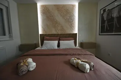 a bedroom with a large bed with towels on it at Apartman 52 in Doboj