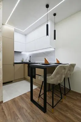 a kitchen with a black table and white cabinets at Apartman 52 in Doboj