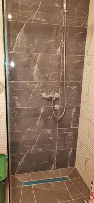 a shower in a bathroom with a stone wall at Sweet Dreams RD in Travnik