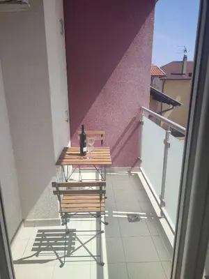 a table with a bottle of wine on a balcony at Mila apartman in Banja Luka