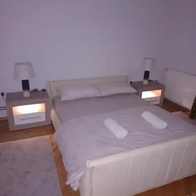 a bedroom with a white bed with two night stands at Nova DOM in Banja Luka