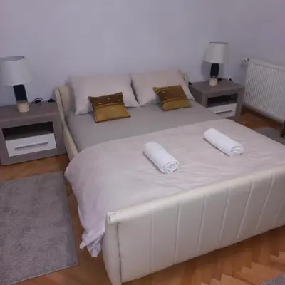 a white bed with two pillows on it in a room at Nova DOM in Banja Luka