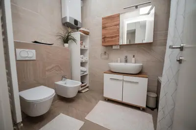 a bathroom with a white toilet and a sink at City Museum Apartments Banja Luka in Banja Luka