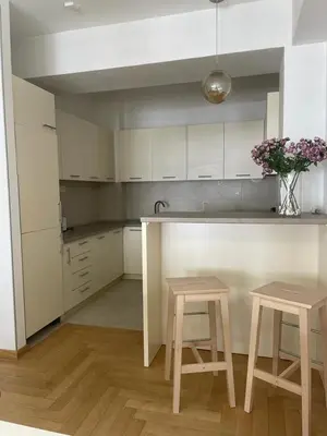 a kitchen with a counter and two stools and a table at City Museum Apartments Banja Luka in Banja Luka