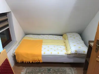 a small bed in a corner of a room at Dream House in Kupres