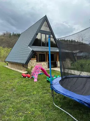 a house with a play set in the yard at Vikendica Mia in Šipovo