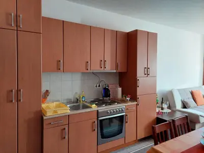 a kitchen with wooden cabinets and a sink at Apartman Pahuljica Vlašić in Vlasic