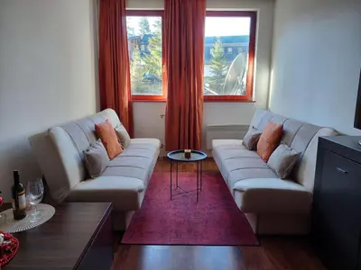 a living room with two couches and a table at Apartman Pahuljica Vlašić in Vlasic