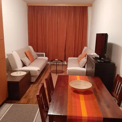 a living room with a table and a tv at Apartman Pahuljica Vlašić in Vlasic