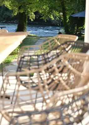 a row of park benches sitting next to a river at Apartmani TIS in Banja Luka