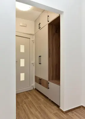 a room with white cabinets and a door at Apartmani TIS in Banja Luka