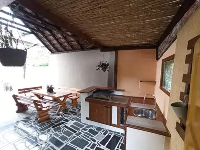 a living room with a table and a kitchen at Kuća za odmor La Mia Casa in Doboj