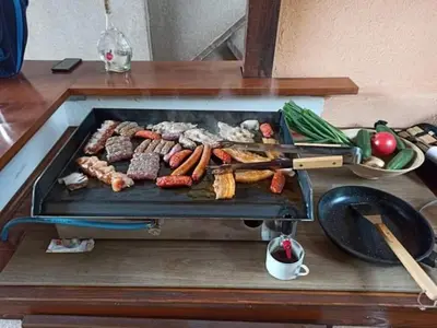 a grill with meat and vegetables on a table at Kuća za odmor La Mia Casa in Doboj